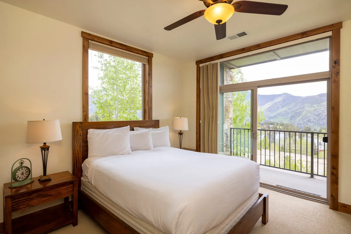 A stylish bedroom with a large window offering sweeping views of the Needles Mountains. The space feels tranquil and welcoming, with subtle touches that invite relaxation—such as enjoying your morning coffee while admiring the scenery.